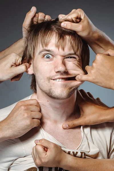 birçok el adam komik yüz yapma, yüz cilt germe