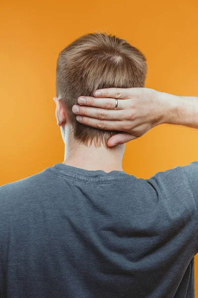 stüdyoda genç adamın kafa dokunmadan arka görünümü