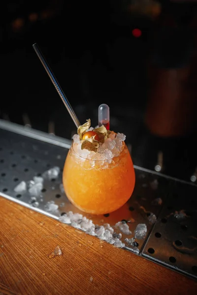 orange cocktail with ice on bar, close up shot