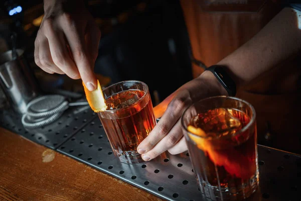 bartender preparing old fashioned cocktails on bar