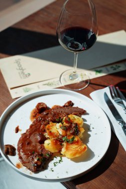 güneş ışığında masada patates ile biftek tabağı