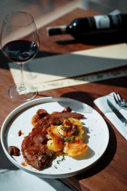 güneş ışığında masada patates ile biftek tabağı