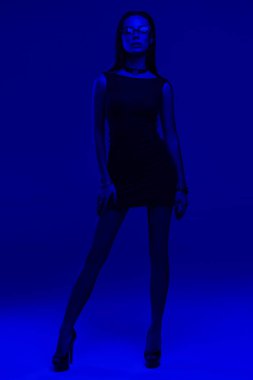 mavi ışıkta poz veren siyah mini elbisegüzel kadın