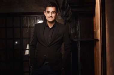 stüdyoda poz takım elbise giyen gülümseyen genç adam