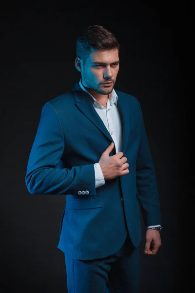 handsome man wearing suit posing on black background in studio