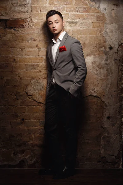 young man wearing suit posing at studio