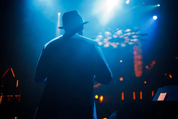 穿着西服 头戴帽子 穿着深色皮肤的歌手 站在舞台上 蓝光闪烁着 优质照片 — 图库照片
