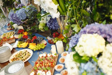 Yemekler ve çiçeklerle servis edilen güzel bir masa.
