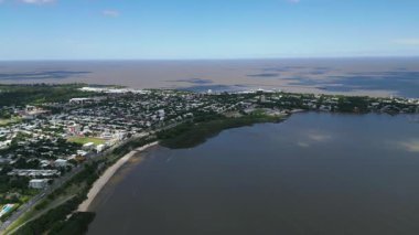 Colonia del Sacramento Uruguay 'ın panoramik hava görüntüsü. Tarihi bölge ve modern şehir Rio de la Plata boyunca harmanlanır. Beyaz koloni binaları yeşil bitki kumlu plajlar ve marina.