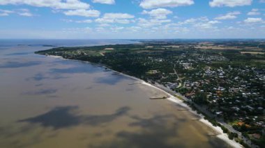 Colonia del Sacramento Uruguay yakınlarındaki plajların havadan görüntüsü. Kumlu kıyı şeridi Rio de la Plata boyunca uzanır ve görünür dalgalar suya doğru uzanır. Yerleşim