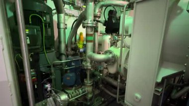 A compartment of a gas compressor unit, highlighting industrial machinery, complex piping, and advanced engineering in operation. This professional footage is ideal for energy industry presentations.