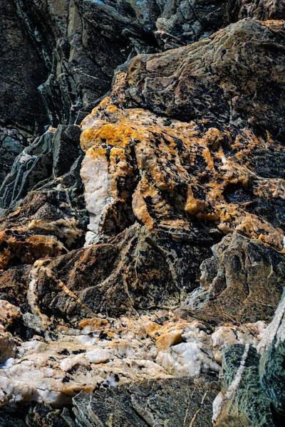 Sahildeki volkanik kayaların dikey yakın çekimi.