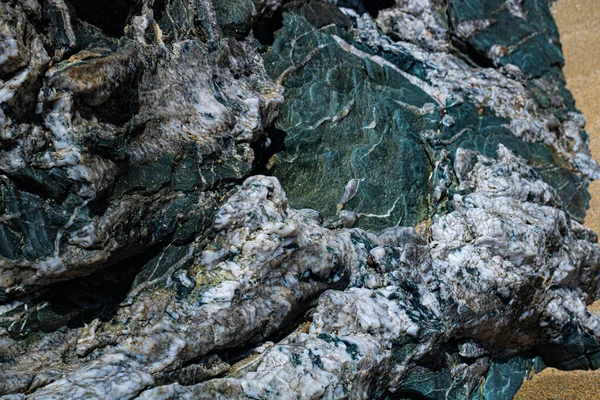 Ateşli kaya dokusunun yakın plan çekimi, kuvars içerikli vahşi İrlanda plajı.