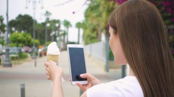 Žena pořizování Foto kužel zmrzliny. Teenagery fotografování zmrzliny na fotoaparát telefonu ve zpomaleném záběru