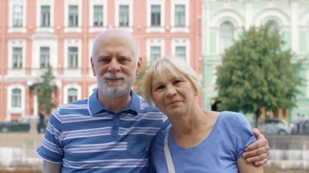 Starší pár stojí na nábřeží kanálu pohledem kamery. Důchodci cestují v Saint Petersburg, Rusko