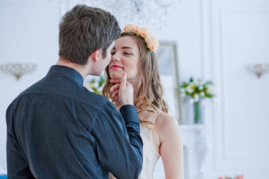 Adam öpmek için kızın çenesini kaldırıyor. Aşık mutlu bir çift. Sevgililer Günü.