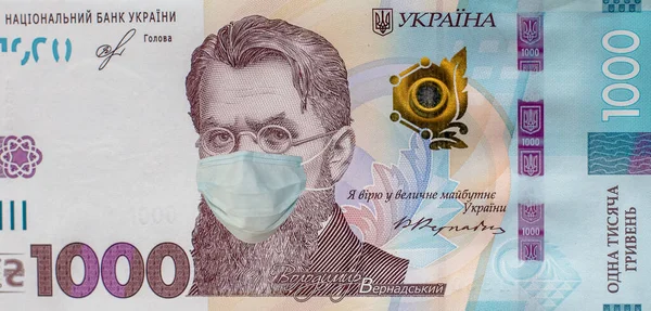 CoV enfeksiyonuna karşı yüz maskeli 1000 hryvnias banknot. Ukrayna 'da Coronavirus. Karantina ve durgunluk kavramı