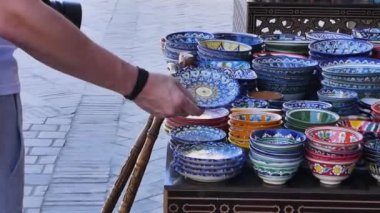 Adam turist Doğu pazarında. İnsan ticareti ve seramik yemekleri oryantal tarzda seçer.