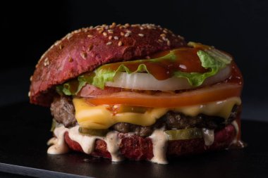 siyah bir zemin üzerine sulu çizburger yakın çekim