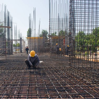 üzerinde işçi güçlendirir ve dökme beton Vakfı için takviye bağlanır. samimi, gerçek insanlar