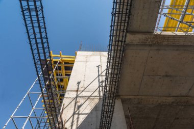 Metal beton yapılar binanın yapım aşamasında. İskele ve gökyüzü arka plan üzerinde destekler. Alt görünümü
