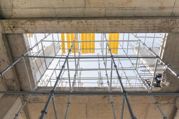 metal concrete structures of the building under construction. scaffolding and supports. bottom view