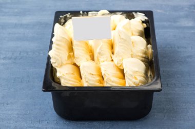 iştah açıcı dondurma dekoratif mavi arka plan üzerinde bir fiyat etiketi ile plastik bir kap içinde