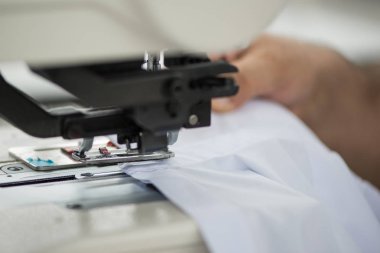 terzi bir dikiş makinesi üzerinde erkek bir gömlek dikiş atölyede yapar. adam makine üzerinde yaka ve manşet diker