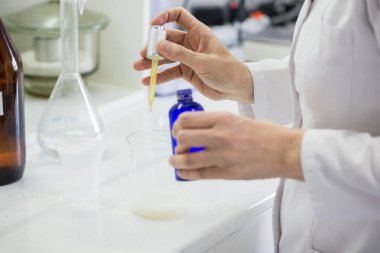 woman testing samples of dairy products in the laboratory. test laboratory of a milk factory clipart