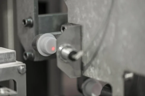 the laser reads the information from the plastic cover on the conveyor. bottle caps at the factory