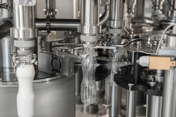 filling milk in to plastic bottles at the factory. equipment at the dairy plant