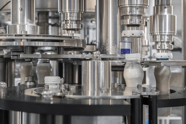 filling milk in to plastic bottles at the factory. equipment at the dairy plant