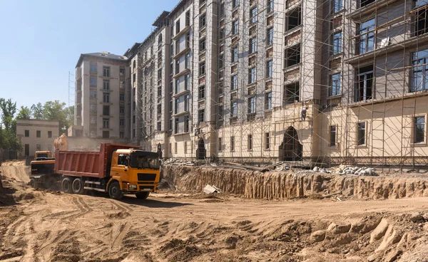 on the construction site, the excavator loads the land into the dump truck