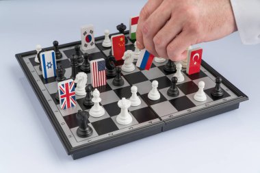 Politikacının el bir satranç parça bir bayrak ile taşır. Kavramsal fotoğraf politik bir oyun. misilleme hareketi Rusya