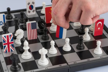 Politikacının el bir satranç parça bir bayrak ile taşır. Kavramsal fotoğraf politik bir oyun. misilleme hareketi Rusya