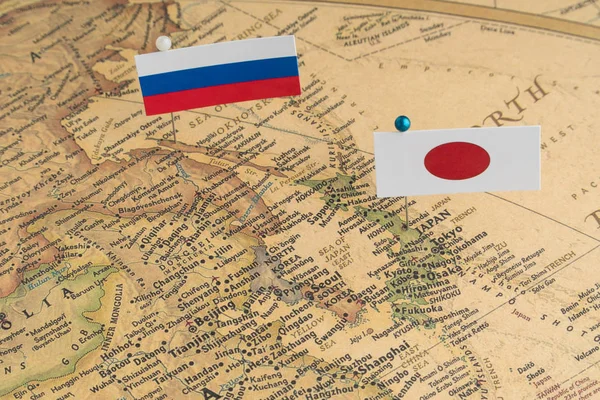 The flags of Russia and Japan on the world map. Conceptual photography, political differences due to Sakhalin island