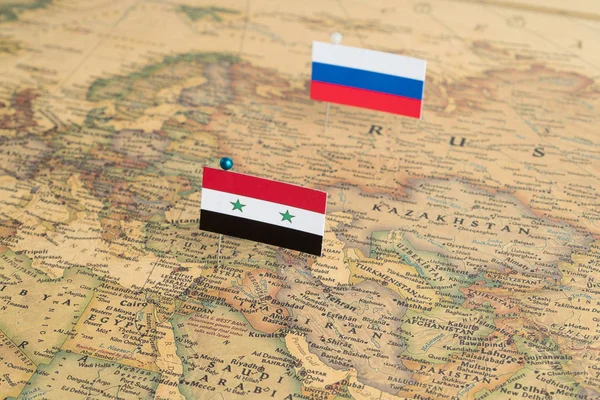 Flags of Russia and Syria on the world map. Conceptual photo, politics and world order