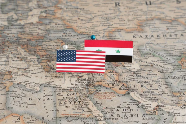 Flags of the USA and Syria on the world map. Conceptual photo, politics and world order, military conflict