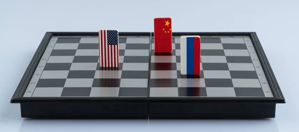 Symbols flag of Russia, USA and China on the chessboard. The concept of political game.