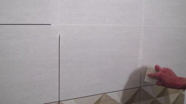Lastik spatula ile çalışan bir çözüm ile dikişleri doldurun. Bitirme işleri, ellere odaklan. Kiremit döşeme teknolojisi.