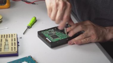 Elektronik mühendis onarım bilgisayar sabit disk. bir tornavida ile teknoist HDD ayrıştırır