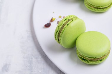 Beyaz tabakta yeşil makarna kurabiyesi. Stüdyo fotoğrafı