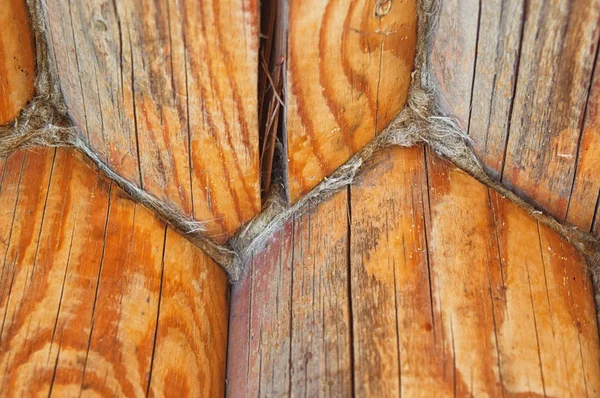 Texture in parallel folded logs. The ancient technology of building a Russian log hut cottages and churches. Treated timber wood.