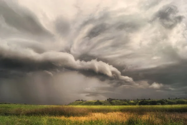 Tarlalar ve çayırlar üzerinde fırtına tepe vadisine yaklaşıyor. Yağmurlu bulutlu bir gün.