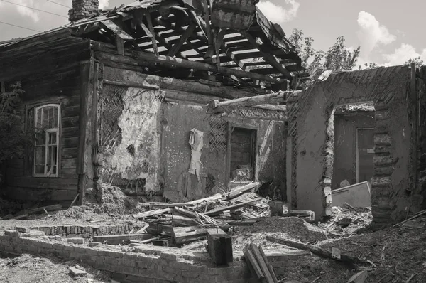 Ruined damaged house. Affected as a result of a natural disaster, the building of private property. Fragment of the destroyed brick wooden house.