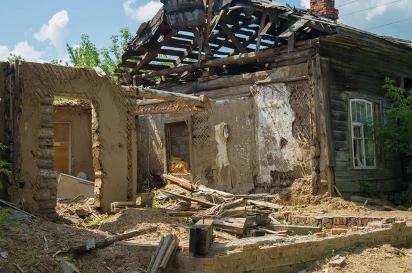 Ruined damaged house. Affected as a result of a natural disaster, the building of private property. Fragment of the destroyed brick wooden house.