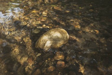 Taş bir dağ güneş altında closeup akarsu.