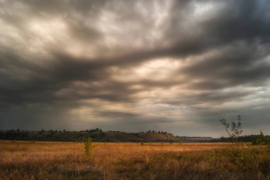 Vadi ve sararmış çayır otları çerçevede Ağustos sabah tepelerde.