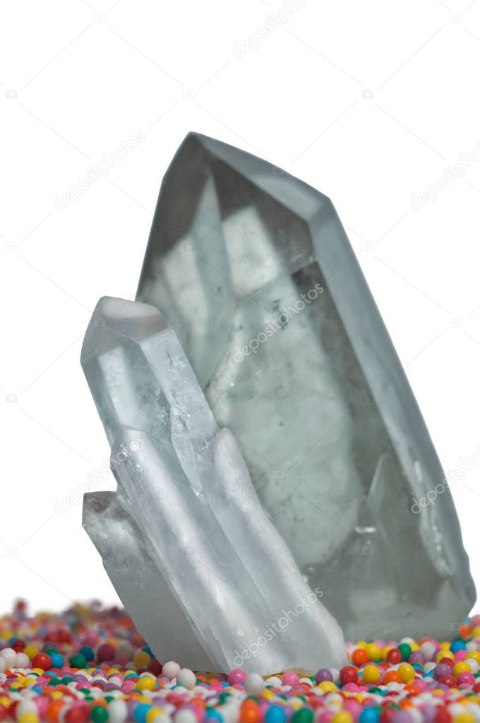 Clear mystical faceted crystal of quartz chalcedony on a multicolored background close-up. Wonderful mineral of the royal size for the designer.