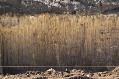 Bir kova Ekskavatör izleri ile doku toprak. Bina inşaat Vakfı için bölüm ocağı çukurun duvar zemin.